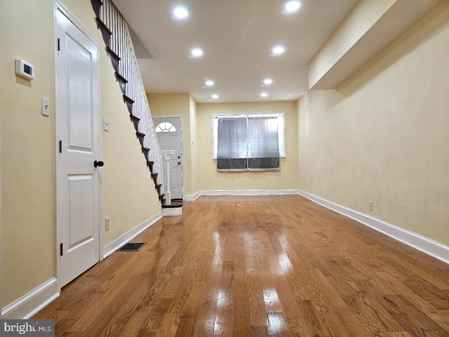 foyer with recessed lighting, baseboards, wood finished floors, and stairway