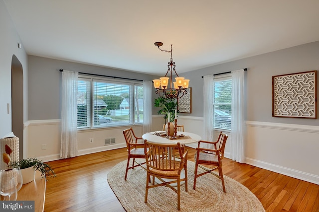 4255 Darleigh Rd, Baltimore, MD 21236 - dining space featuring arched walkways, light wood finished floors, a chandelier, and baseboards