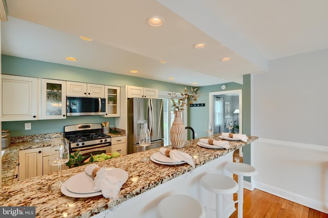 4255 Darleigh Rd, Baltimore, MD 21236 - kitchen featuring stainless steel appliances, light stone counters, a kitchen bar, light wood-style flooring, and recessed lighting