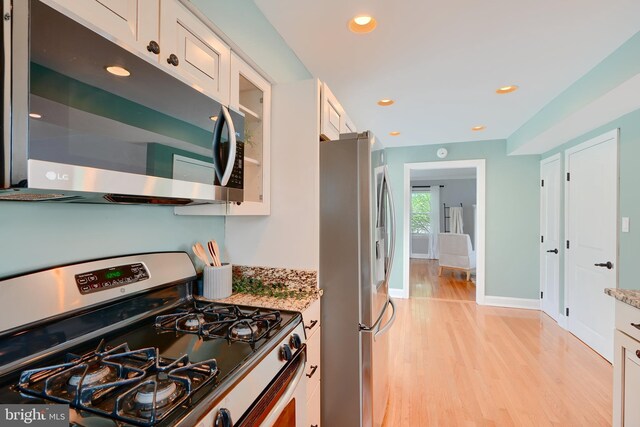 4255 Darleigh Rd, Baltimore, MD 21236 - kitchen featuring stainless steel appliances, light wood-type flooring, white cabinets, light stone countertops, and baseboards