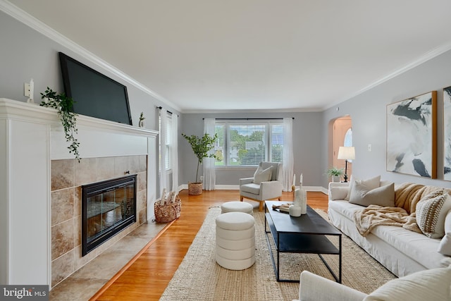 4255 Darleigh Rd, Baltimore, MD 21236 - living area with a fireplace, crown molding, light wood finished floors, arched walkways, and baseboards