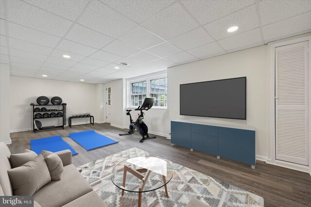 exercise room featuring wood finished floors, a drop ceiling, baseboards, and recessed lighting