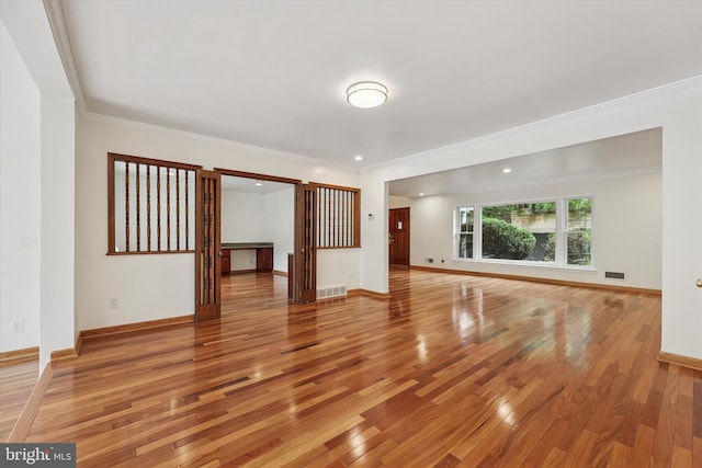 unfurnished living room featuring light wood-style floors, crown molding, baseboards, and recessed lighting
