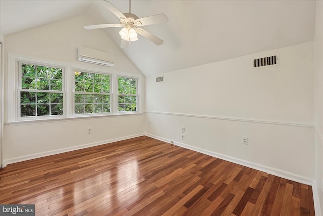 spare room with an AC wall unit, a ceiling fan, lofted ceiling, wood finished floors, and baseboards
