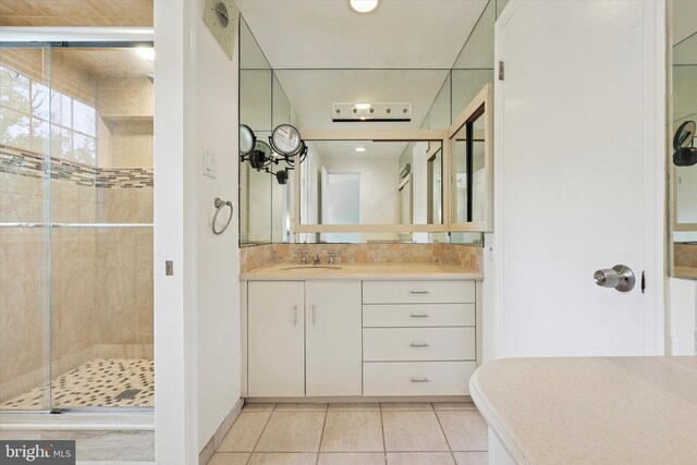 bathroom with a stall shower, tile patterned floors, vanity, and backsplash