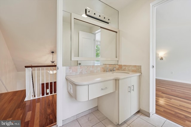 bathroom with decorative backsplash, tile patterned flooring, vanity, and baseboards