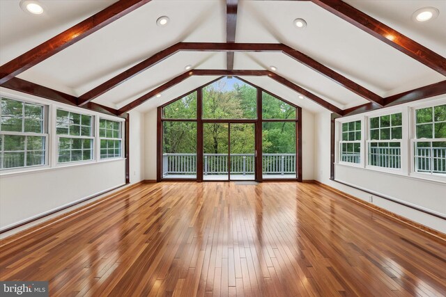 unfurnished living room with wood-type flooring, healthy amount of natural light, and baseboards