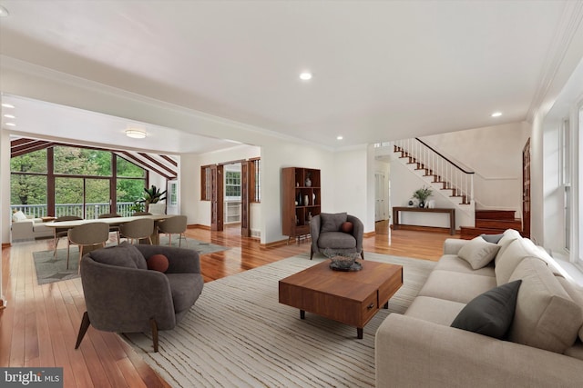 living area featuring stairway, light wood-style floors, crown molding, baseboards, and recessed lighting