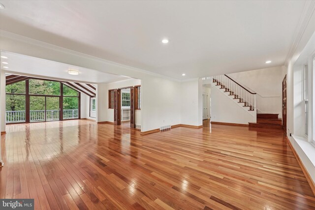 unfurnished living room with light wood-type flooring, ornamental molding, stairway, baseboards, and recessed lighting