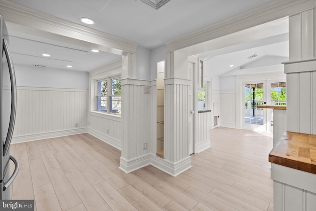 corridor featuring a decorative wall, visible vents, a wainscoted wall, and light wood-style floors