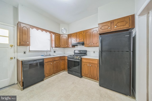 2426 S Chadwick St, Philadelphia, PA 19145 - kitchen featuring a sink, light countertops, brown cabinetry, under cabinet range hood, and black appliances
