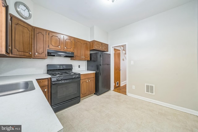 2426 S Chadwick St, Philadelphia, PA 19145 - kitchen with a sink, light countertops, under cabinet range hood, visible vents, and black appliances