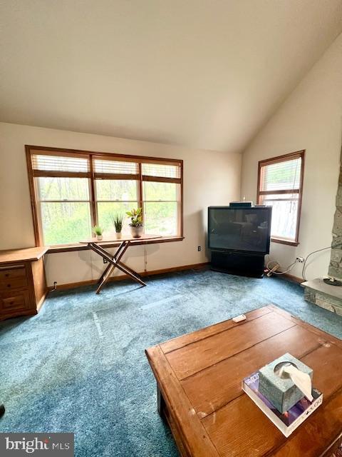 living area featuring baseboards, carpet flooring, and vaulted ceiling