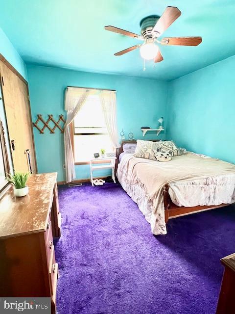 bedroom featuring a ceiling fan and dark colored carpet