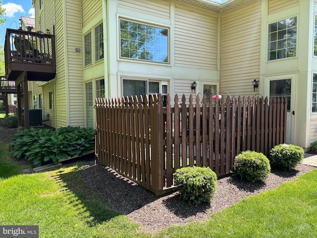 view of property exterior with central AC and fence