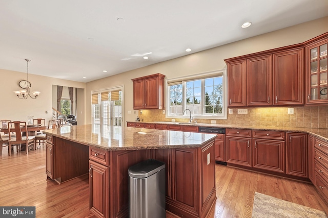 kitchen with a sink, plenty of natural light, light wood-style floors, and a kitchen island