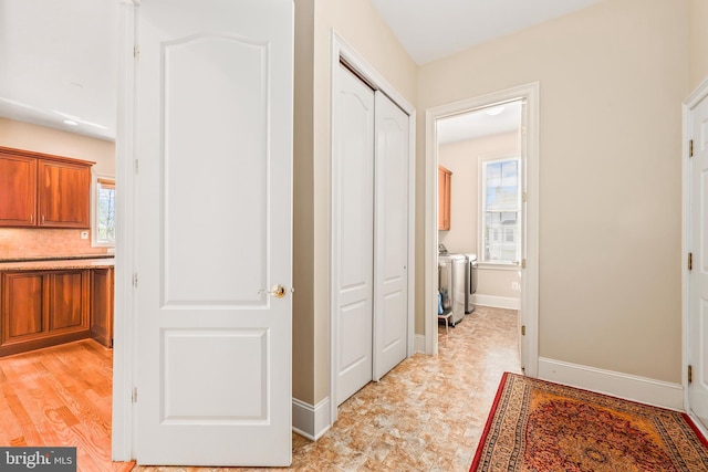 hallway featuring baseboards and washer and dryer