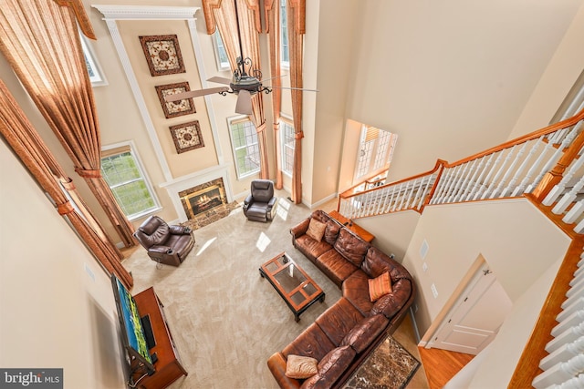 living area with baseboards, a towering ceiling, stairway, and a fireplace