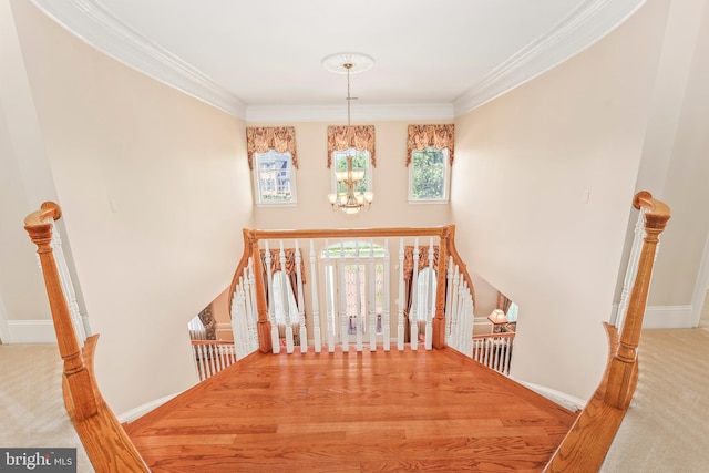 interior space with baseboards, ornamental molding, and a notable chandelier