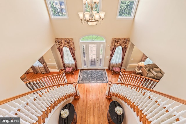 foyer with a high ceiling, a chandelier, stairs, baseboards, and wood finished floors