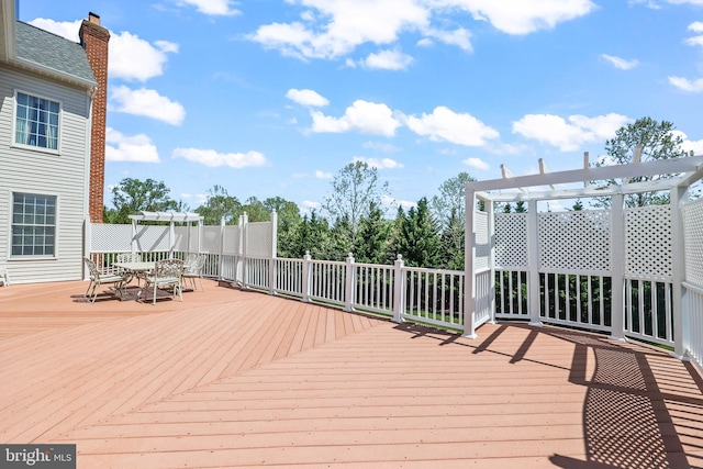 wooden deck featuring a pergola and outdoor dining space