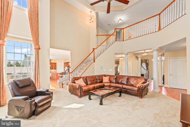 living room featuring a ceiling fan, decorative columns, a high ceiling, and a healthy amount of sunlight