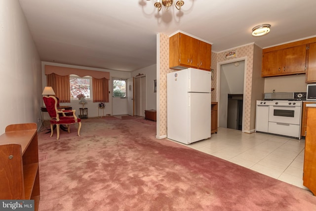 kitchen with white appliances, baseboards, brown cabinetry, and light carpet