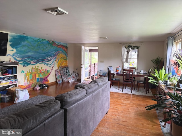 living area featuring plenty of natural light, visible vents, and light wood-type flooring