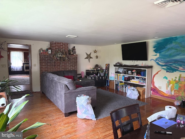 living room featuring visible vents, light wood-style floors, and a fireplace