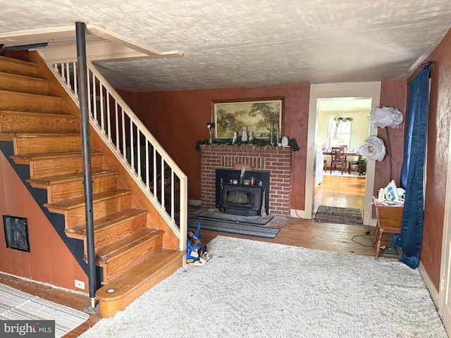 stairs featuring a wood stove and wood finished floors