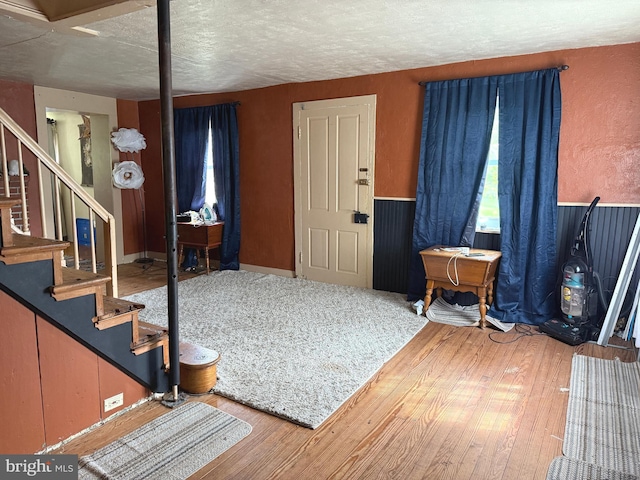 entrance foyer with stairway, a textured ceiling, and wood finished floors