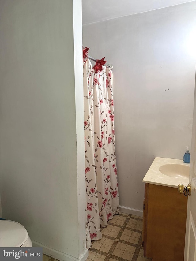 bathroom featuring vanity, toilet, tile patterned floors, a shower with shower curtain, and baseboards