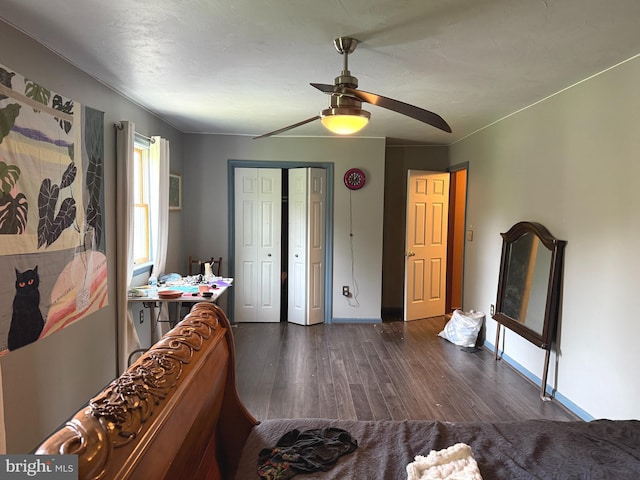 bedroom featuring baseboards, ceiling fan, dark wood-style floors, and a closet