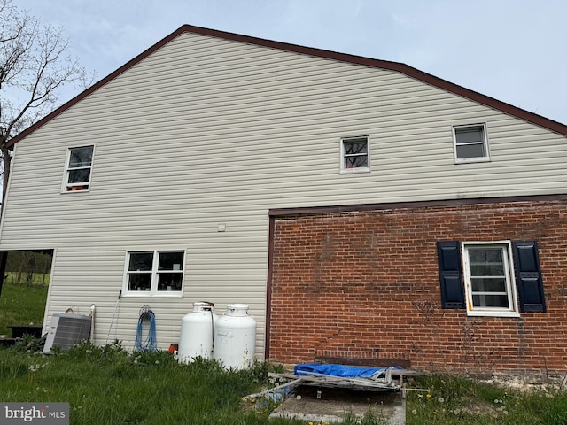 view of side of property with brick siding and cooling unit