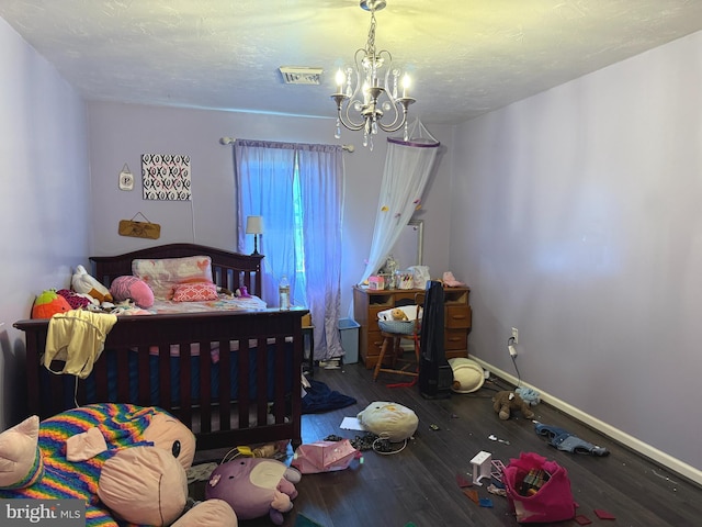 bedroom featuring visible vents, hardwood / wood-style floors, baseboards, a textured ceiling, and a chandelier