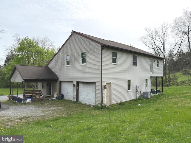 view of home's exterior with a yard, central AC, driveway, and an attached garage