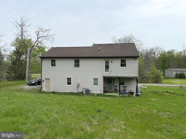 rear view of property featuring a yard and central AC