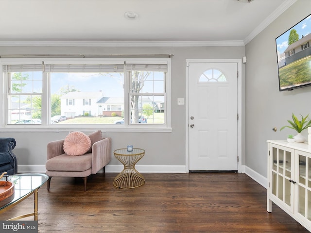 foyer entrance with crown molding, baseboards, and wood finished floors