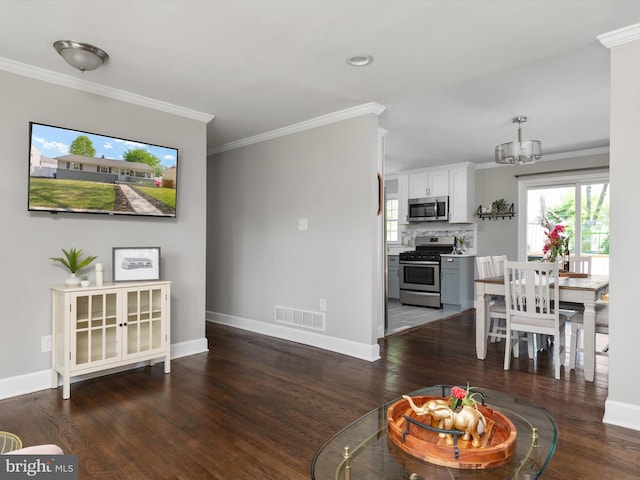 living room with crown molding, baseboards, visible vents, and wood finished floors