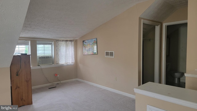 807 Riverside Dr, Pasadena, MD 21122 - empty room featuring a textured ceiling, vaulted ceiling, carpet, baseboards, and cooling unit