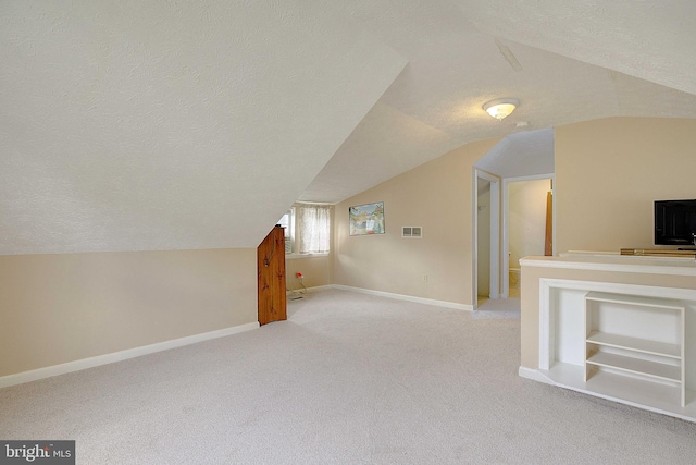 807 Riverside Dr, Pasadena, MD 21122 - additional living space with vaulted ceiling, a textured ceiling, light colored carpet, and baseboards