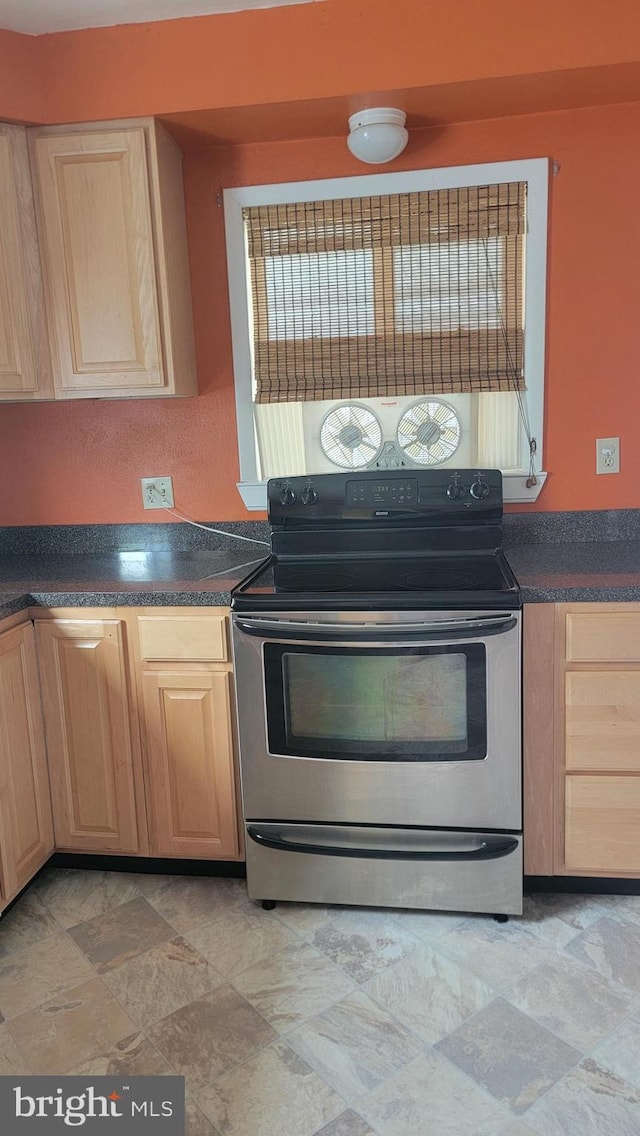 807 Riverside Dr, Pasadena, MD 21122 - kitchen with electric stove, light brown cabinetry, dark countertops, and stone finish floors