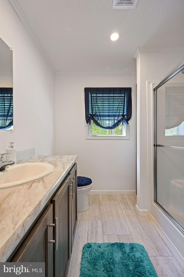 full bathroom featuring crown molding, vanity, toilet, wood finished floors, and a shower with door