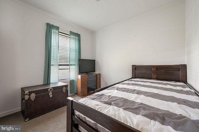 bedroom featuring crown molding, baseboards, and carpet flooring