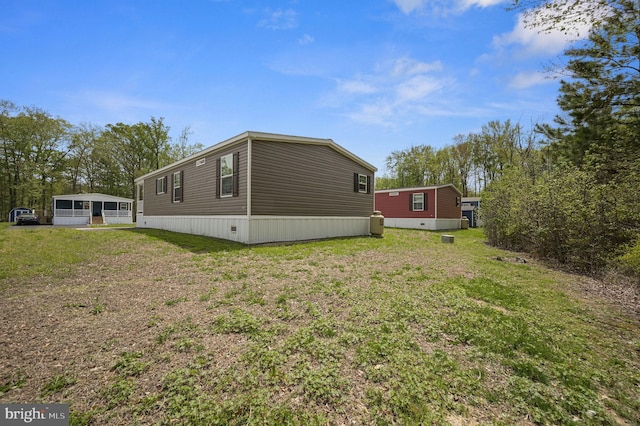 view of side of property featuring a sunroom and a yard