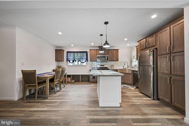 kitchen with a center island, recessed lighting, appliances with stainless steel finishes, and wood finished floors