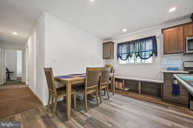 dining space with crown molding, recessed lighting, baseboards, and wood finished floors