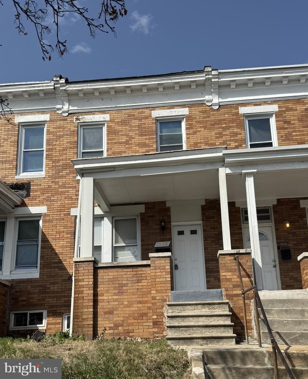 property entrance featuring brick siding and a porch