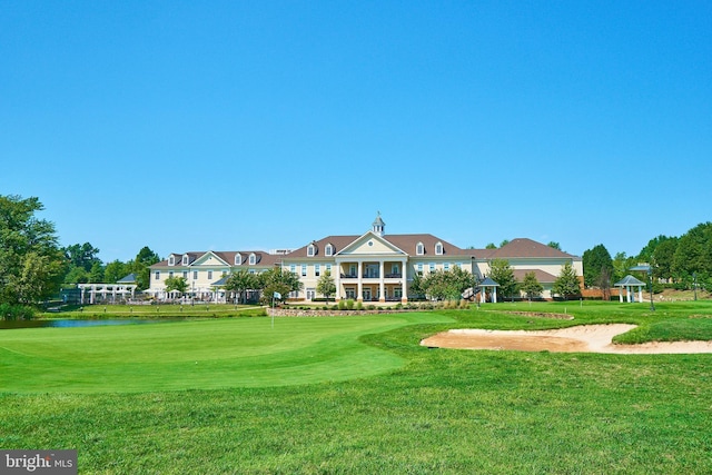 surrounding community with view of golf course and a yard