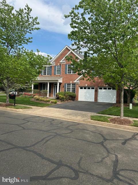 15201 Weiskopf Ct, Haymarket, VA 20169 - view of front of house with driveway, brick siding, and a porch
